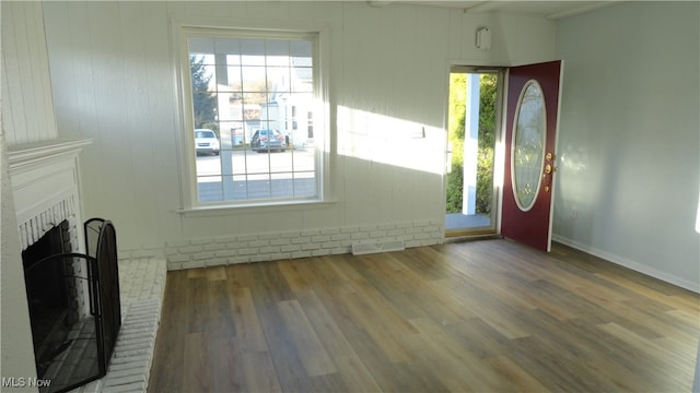 interior space with a wealth of natural light, wood-type flooring, and a fireplace