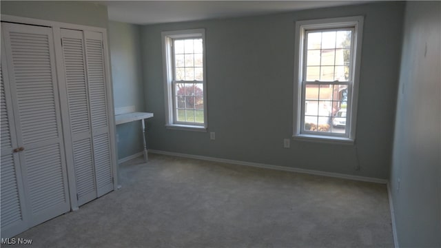 unfurnished bedroom featuring multiple windows and carpet floors