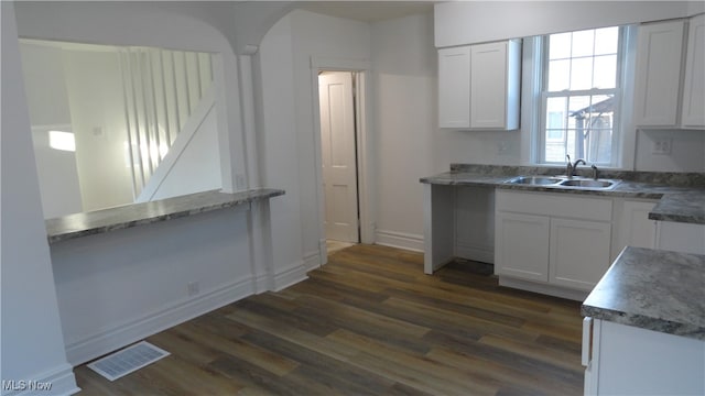 kitchen with white cabinets, sink, and dark hardwood / wood-style floors