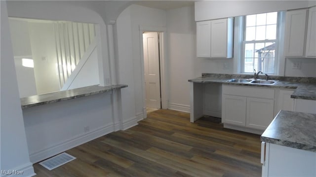 128 Columbia, Chester, WV 26034 - kitchen featuring a sink, dark wood-style floors, white cabinets, and baseboards