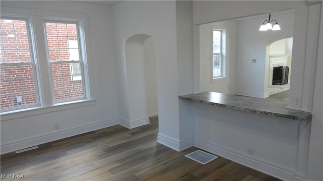 128 Columbia, Chester, WV 26034 - unfurnished dining area with arched walkways, wood finished floors, healthy amount of natural light, and baseboards