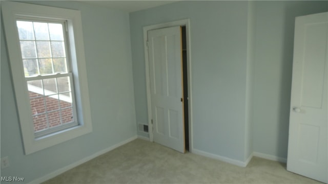 unfurnished bedroom featuring light carpet