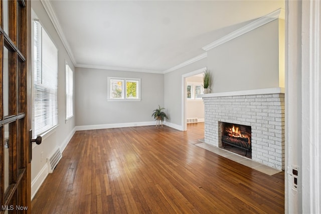 unfurnished living room with a brick fireplace, wood-type flooring, and ornamental molding