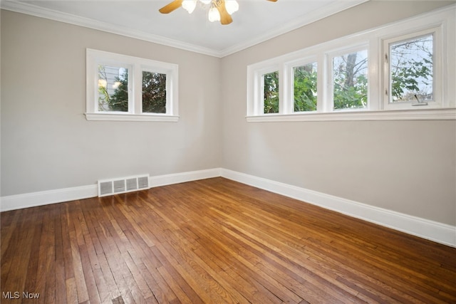 empty room with hardwood / wood-style floors, a wealth of natural light, ceiling fan, and crown molding