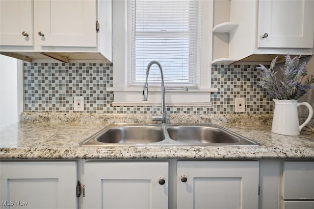 kitchen with white cabinets, sink, and decorative backsplash