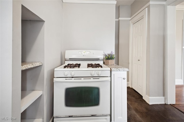 kitchen with dark wood-type flooring, light stone counters, and white gas range