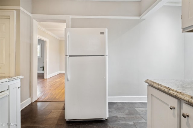 kitchen featuring dark hardwood / wood-style flooring, white refrigerator, ornamental molding, light stone countertops, and white cabinetry