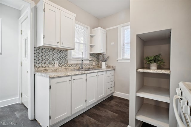 kitchen featuring white cabinetry, sink, tasteful backsplash, and white stove