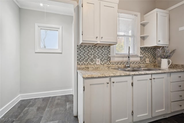 kitchen featuring white cabinetry, sink, backsplash, and light stone counters