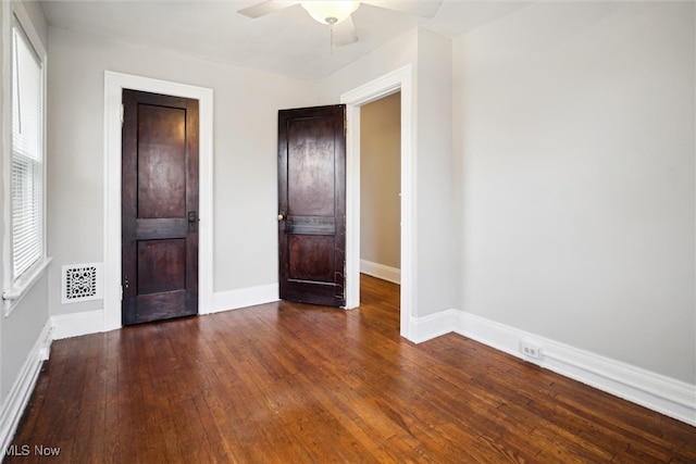 unfurnished bedroom featuring dark wood-type flooring and ceiling fan