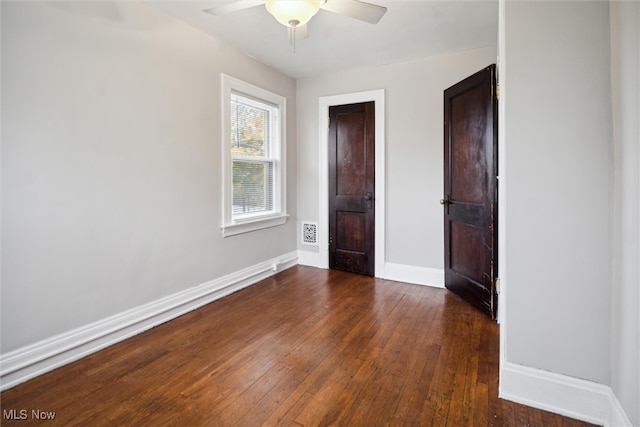 unfurnished bedroom with ceiling fan and dark hardwood / wood-style flooring