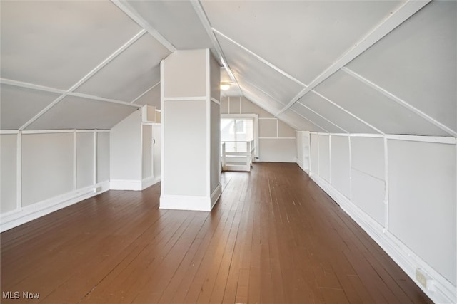 additional living space featuring dark wood-type flooring and lofted ceiling