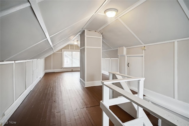 additional living space with dark wood-type flooring and lofted ceiling