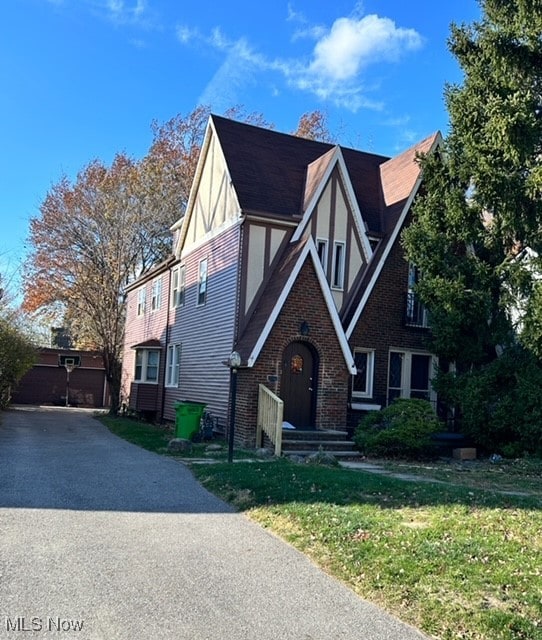 tudor-style house with a front yard