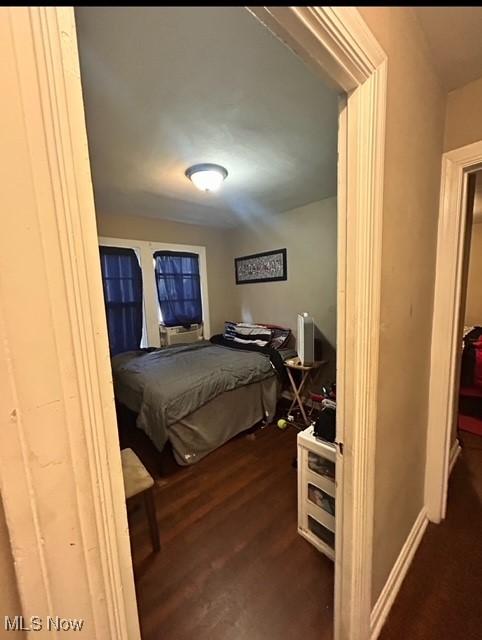 bedroom with dark hardwood / wood-style flooring