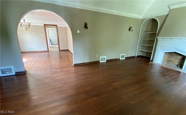 unfurnished living room featuring dark hardwood / wood-style floors, lofted ceiling, ornamental molding, and an inviting chandelier