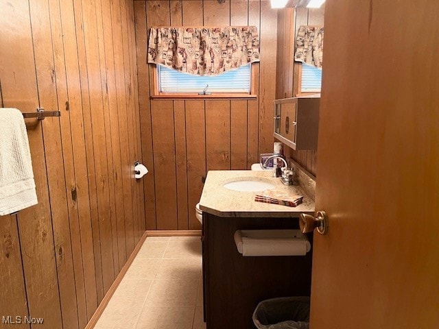 bathroom with wood walls, vanity, and tile patterned floors