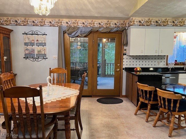 dining space with a textured ceiling and a notable chandelier