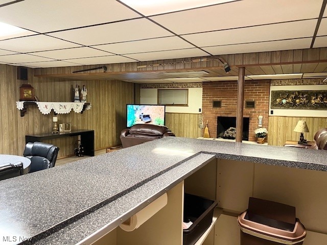 kitchen featuring a drop ceiling and wood walls