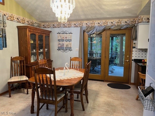 dining space with a chandelier, a textured ceiling, and vaulted ceiling