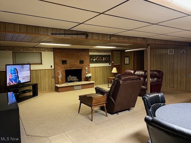 living room featuring wood walls and a fireplace