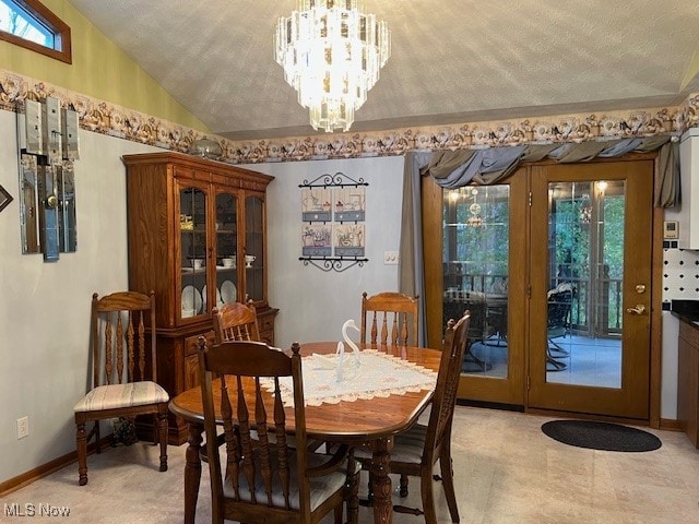 dining area featuring a textured ceiling, an inviting chandelier, and vaulted ceiling