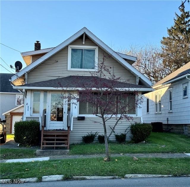 bungalow-style home with a front yard