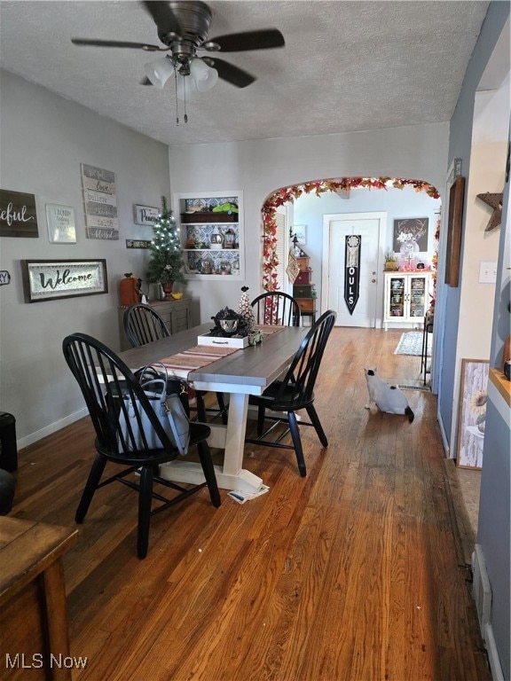 dining space with hardwood / wood-style floors, ceiling fan, and a textured ceiling