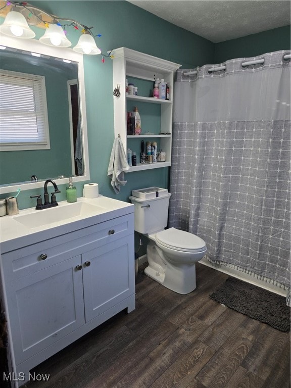 bathroom with hardwood / wood-style flooring, a shower with curtain, a textured ceiling, vanity, and toilet