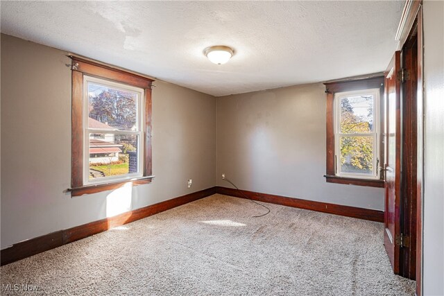 carpeted spare room featuring a textured ceiling