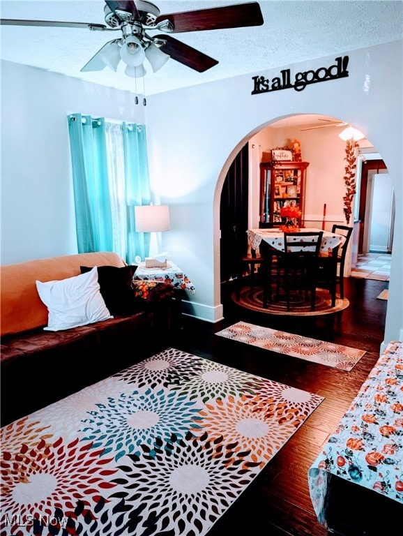 living room featuring hardwood / wood-style floors, a textured ceiling, and ceiling fan