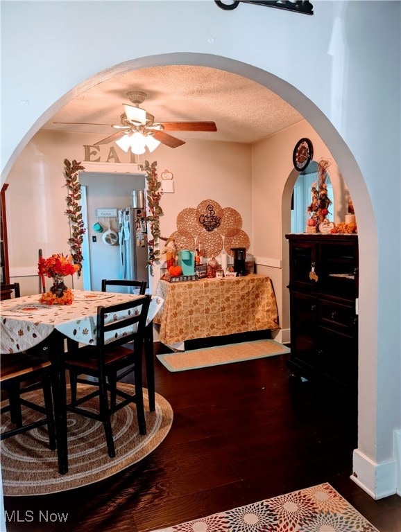 dining area with ceiling fan, dark hardwood / wood-style floors, and a textured ceiling