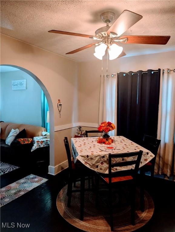 dining area featuring hardwood / wood-style flooring, ceiling fan, and a textured ceiling