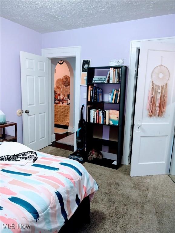 carpeted bedroom with a textured ceiling