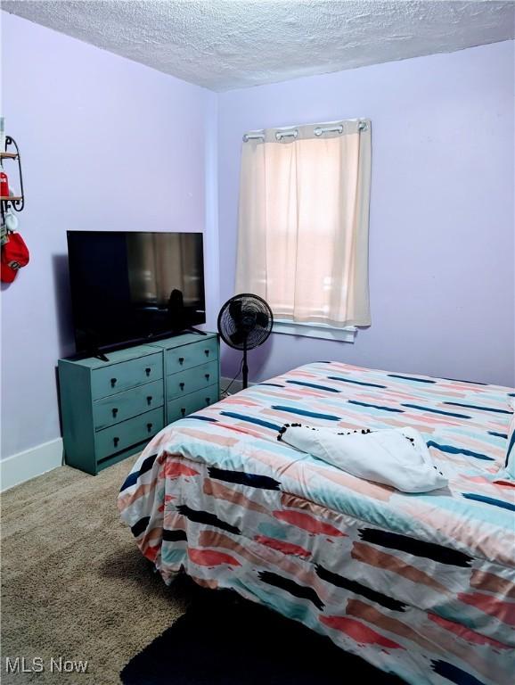 carpeted bedroom featuring a textured ceiling