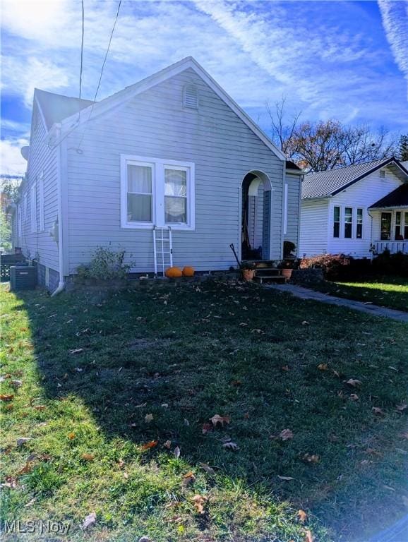 view of front of house featuring a front lawn and central air condition unit