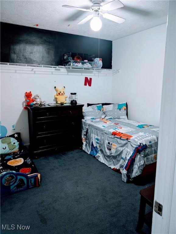 bedroom with ceiling fan and dark colored carpet