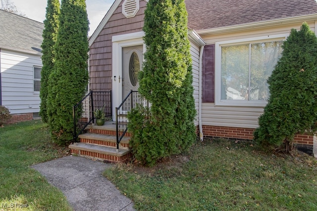 view of exterior entry with a lawn