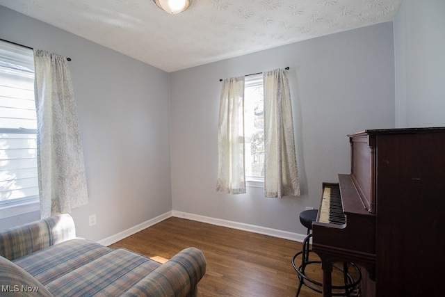 sitting room with a textured ceiling, plenty of natural light, and dark hardwood / wood-style floors