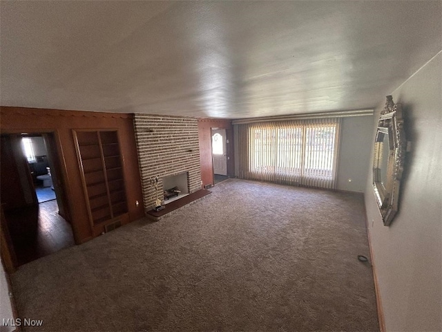 unfurnished living room with carpet and a brick fireplace