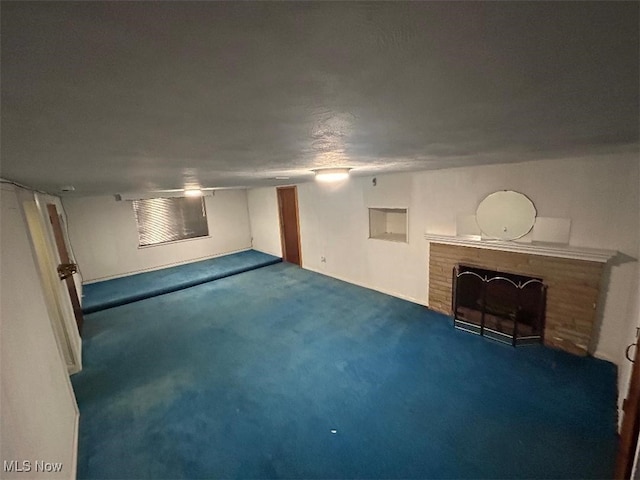 basement with a brick fireplace and dark carpet