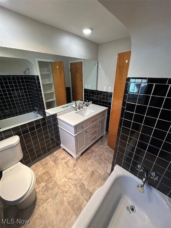 full bathroom featuring vanity, toilet, tile walls, and tiled shower / bath combo