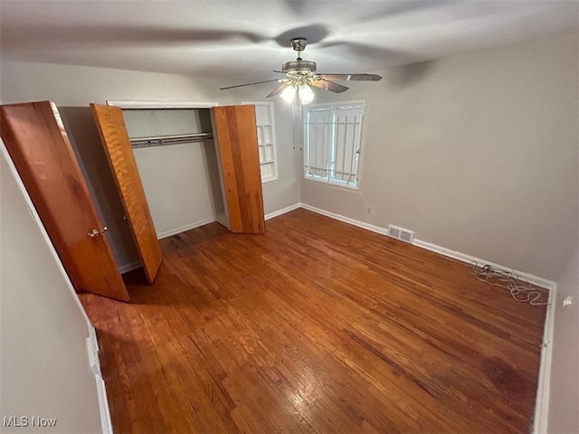 unfurnished bedroom with a closet, hardwood / wood-style flooring, and ceiling fan