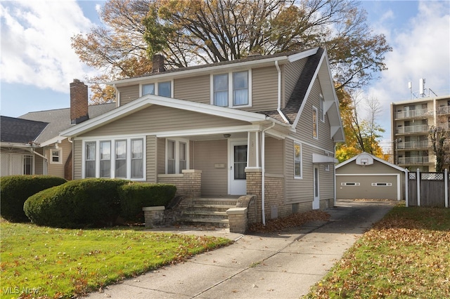 view of front of house with a porch, a garage, an outbuilding, and a front lawn