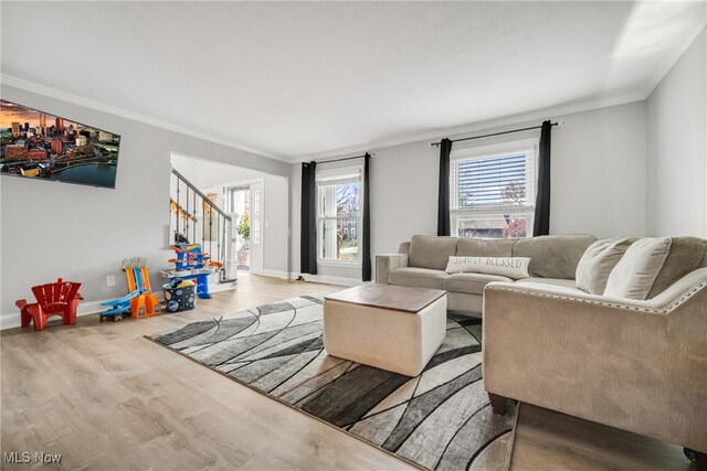 living room with light wood-type flooring and ornamental molding