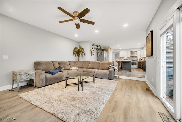 living room featuring ceiling fan and light hardwood / wood-style flooring