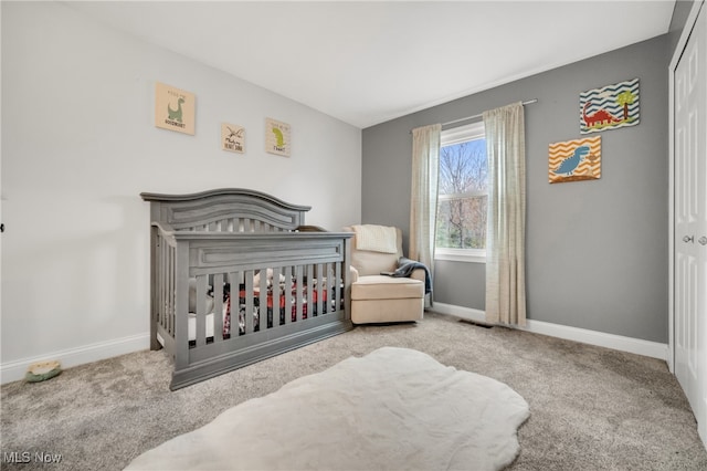 bedroom featuring a crib and light carpet