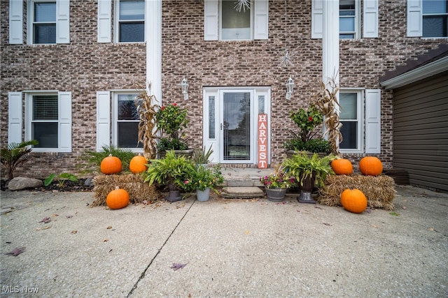 view of exterior entry with a patio