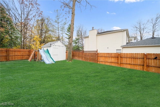 view of yard with a playground and a storage unit