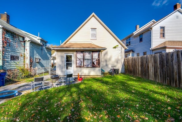 back of property with a lawn and a patio